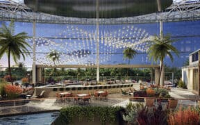 Pacific Gaylord Resort atrium with palm trees, water feature and seating area.