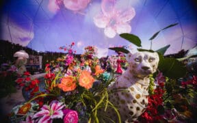 A jungle wildcat statue is surrounded by tropical flowers in the The District Dome at Desert Ridge Marketplace.