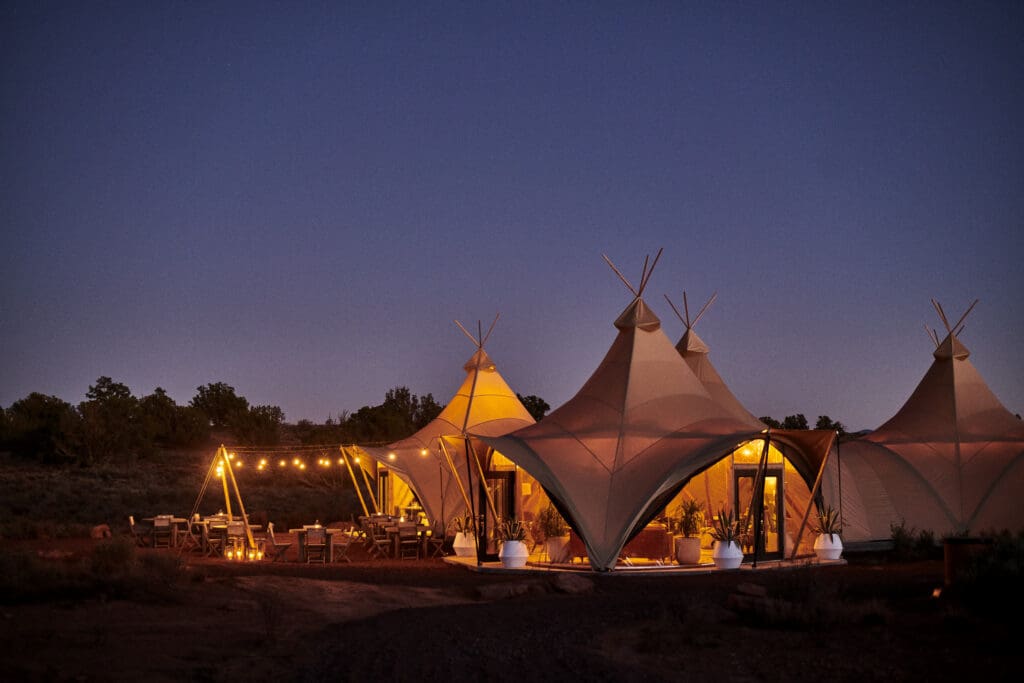 Under Canvas lit up luxury yurts under a night sky.