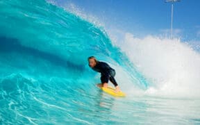 A surfer at Cannon Beach in Mesa, AZ is surfing on a wave.