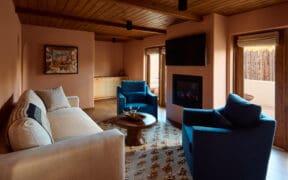 A couch and two chairs with a coffee table atop a woven rug at the Hotel Willa in Taos, New Mexico.