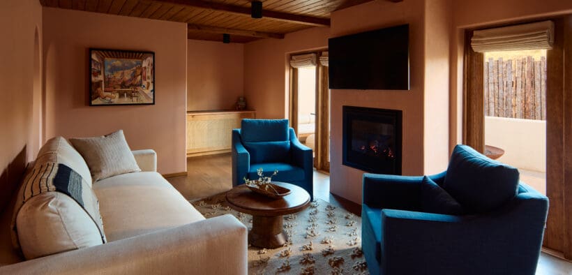 A couch and two chairs with a coffee table atop a woven rug at the Hotel Willa in Taos, New Mexico.