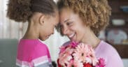 A daughter and mother touch foreheads after the daughter presented her mom with flowers for Mother's Day.