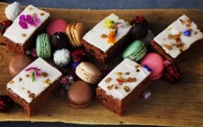 An assortment of Mother's Day cakes and macarons on a tray from the Urban Farmer.