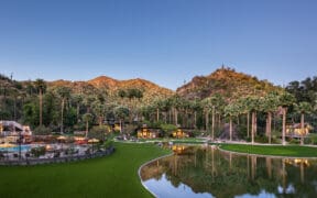 Castle Hot Springs resort with a mountain backdrop, bond, pool and palm trees.