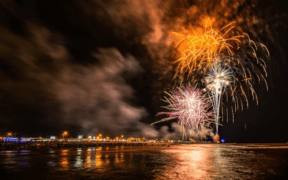 Fourth of July in Galveston featuring fireworks over the water with the city in the background.