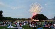 Guests of the Hyatt Regency Hill Country Resort and Spa sit on the property's lawn watching fireworks.