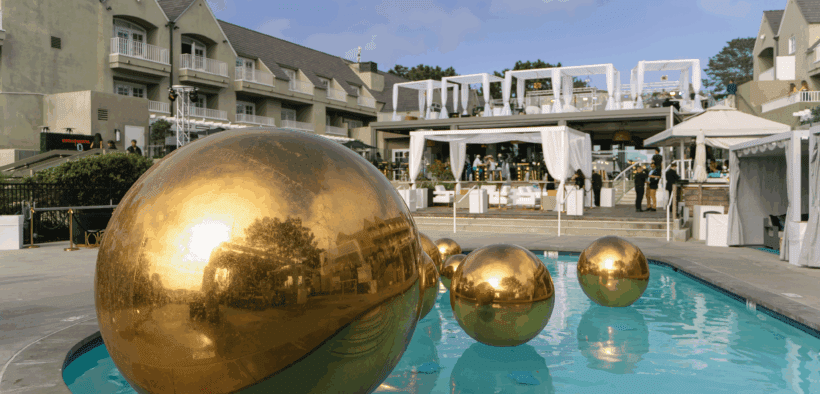 Several gold orbs float in a swimming pool at L’Auberge Del Mar for the Dolce Vita by the Sea event.