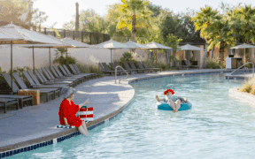 Mrs. Claus sits on the side of the JW Marriott Phoenix Desert Ridge Resort & Spa watching Santa float by on a floatie.