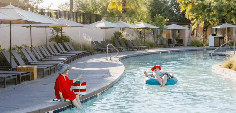Mrs. Claus sits on the side of the JW Marriott Phoenix Desert Ridge Resort & Spa watching Santa float by on a floatie.
