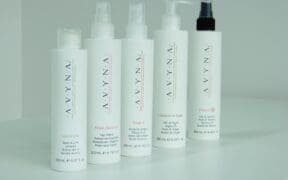 A line of Avyna Cosmetics hair products lined up on a counter.