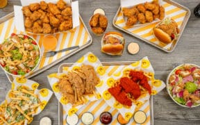 Starbird chicken dishes on trays and a table at a Denver restaurant.