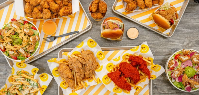 Starbird chicken dishes on trays and a table at a Denver restaurant.