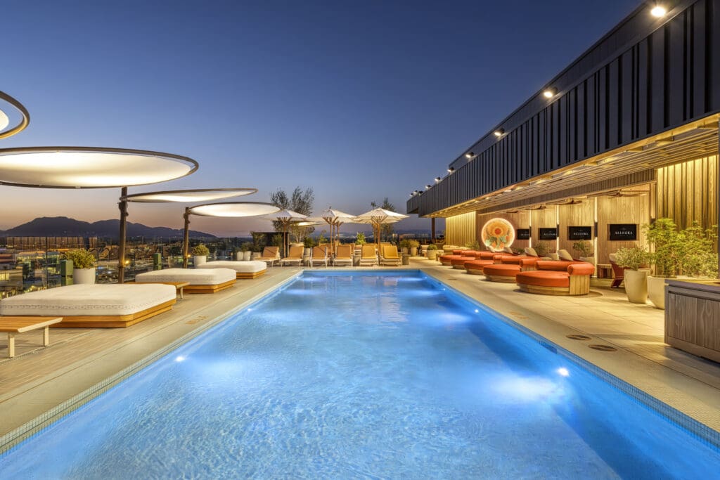 The rooftop pool with comfortable seating and covered daybeds at The REMI Scottsdale.