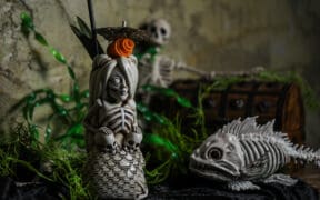 A spooky skeletal mermaid drink holder next to a skeletal fish at a Black Lagoon Pop-up.