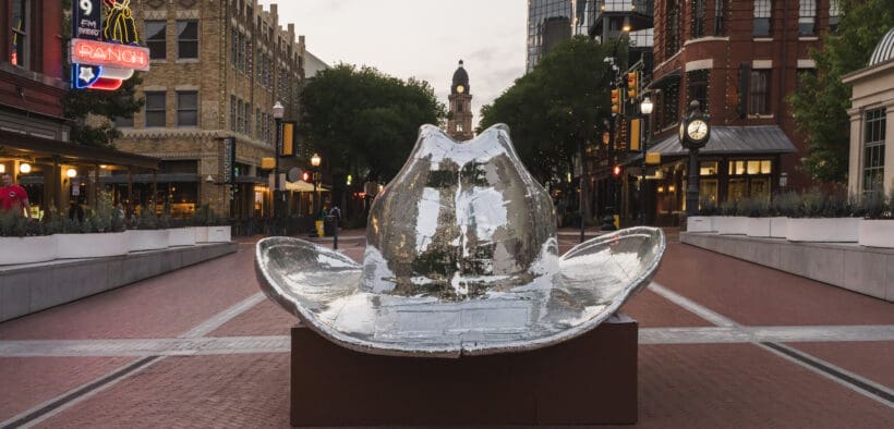 The stockyards of Fort Worth with a large silver cowboy hat installation in the center square.