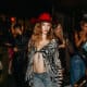 A model at Scottsdale Fashion Week wears a red fedora, zebra print cover up, bra top and jeans.