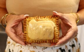 A woman holds a scratch-made pumpkin spice latte (PSL) pop tart from Moon Raccoon Baking Company.