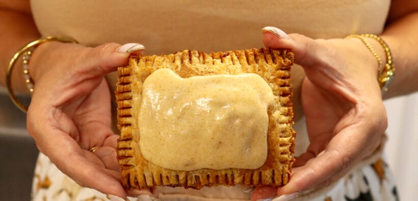 A woman holds a scratch-made pumpkin spice latte (PSL) pop tart from Moon Raccoon Baking Company.