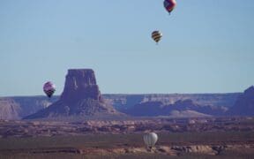 Three hot air balloons in various positions in the sky in Page, Arizona, for the annual Balloon Regatta.