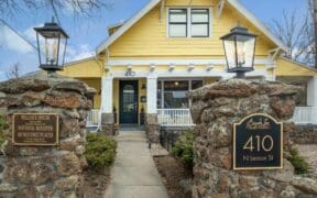 A street view of the historic Bespoke Inn Flagstaff botique hotel with brick pillars and historic designation plaque.