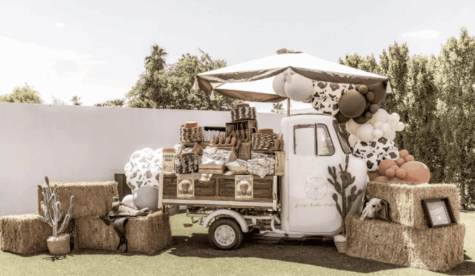 Fiore Della Vita's vintage truck, "Angela" surrounded by haystacks, balloons, crates and other event decor.