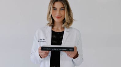 Marissa Adbo of Aesthetic IQ Clinic holds a book in her hands.