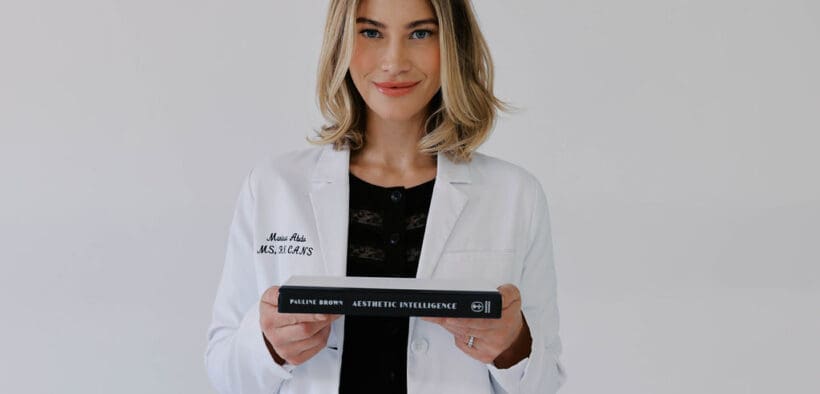 Marissa Adbo of Aesthetic IQ Clinic holds a book in her hands.