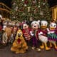 Mickey Mouse, Minnie Mouse and their pals wearing festive outfits in front of a Christmas tree for the Holidays at the Disneyland Resort, in Anaheim, Calif.