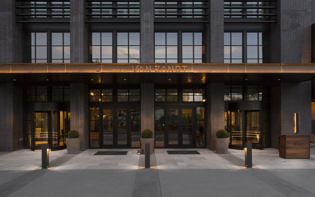 The exterior of Hotel Van Zandt with high windows and lobby. 