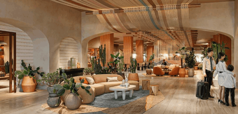 A family of three checks into the modern decorated lobby in earth tones at Kimpton Miralina Resort & Villas in Paradise Valley.