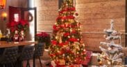 Two decorated Christmas trees with presents underneath at Culinary Drop Out in Phoenix.