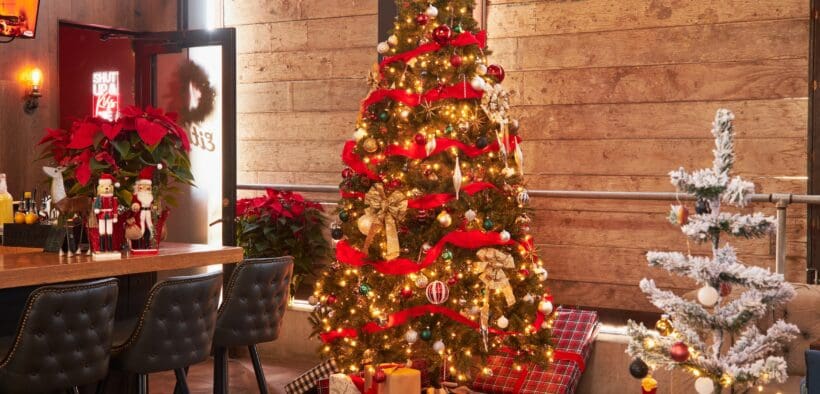 Two decorated Christmas trees with presents underneath at Culinary Drop Out in Phoenix.