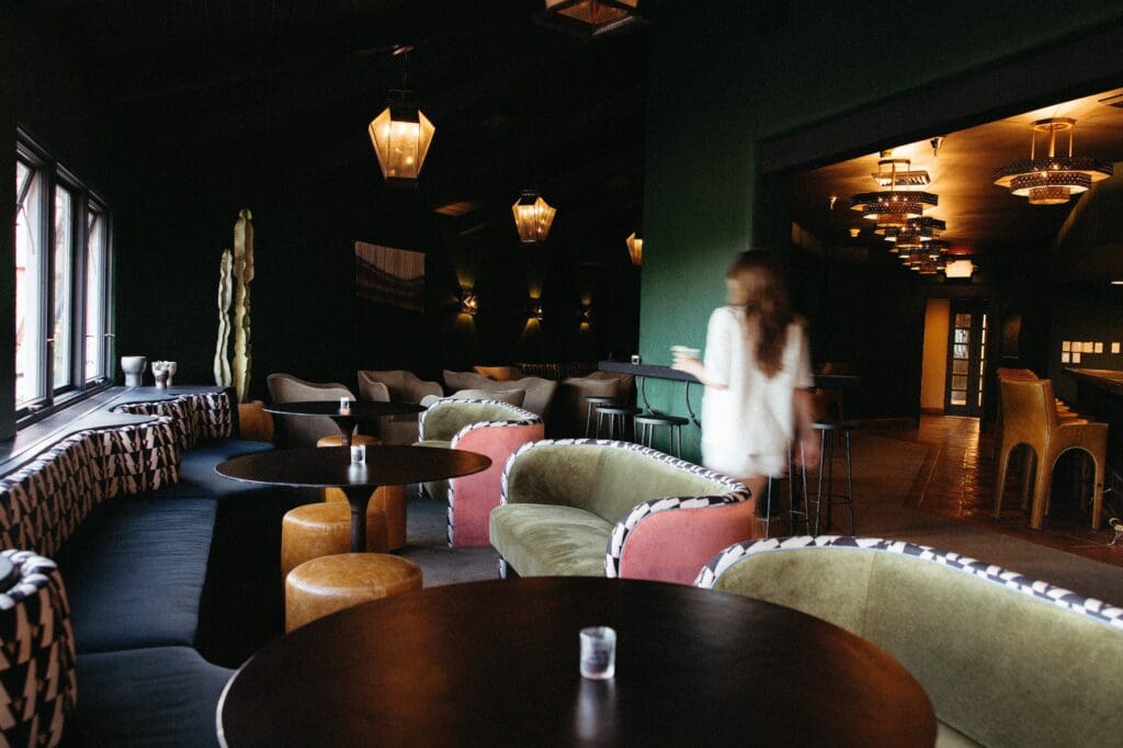 Interior of Lady Duff’s Lounge at Hotel Glorieta in Santa Fe featuring velvet seating, warm lighting and intimate cocktail tables.