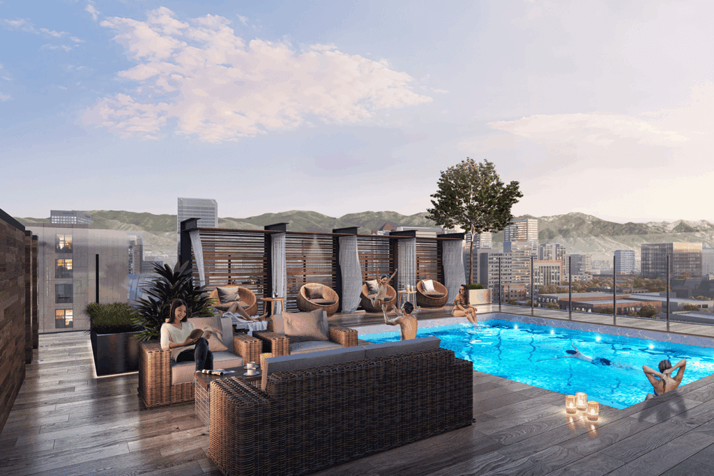 People lounge on sofas and the pool on the rooftop of Le Méridien & Element Salt Lake City.