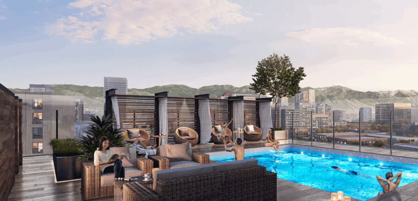 People lounge on sofas and the pool on the rooftop of Le Méridien & Element Salt Lake City.
