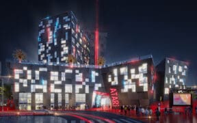 A rendering of the outside of the new Phoenix Atari Hotel coming in 2026 lit up at night.