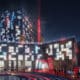 A rendering of the outside of the new Phoenix Atari Hotel coming in 2026 lit up at night.
