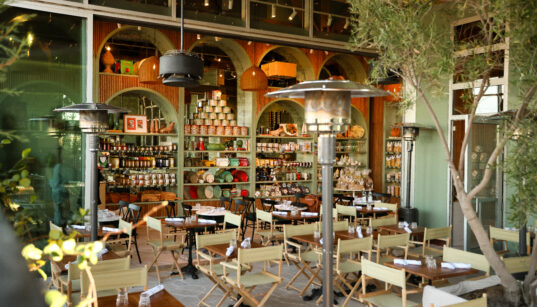 The outside patio of Songno Toscano with folding canvas chairs and trees in Phoenix.