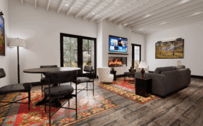 The living and dining area of the Washington Inn Santa Fe, with a table and chairs, a couch and TV.