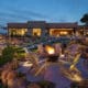 Fire bowl surrounded by seating on a landscaped event lawn at Sanctuary Camelback Mountain Resort & Spa at dusk