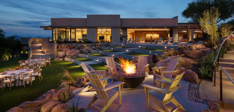 Fire bowl surrounded by seating on a landscaped event lawn at Sanctuary Camelback Mountain Resort & Spa at dusk