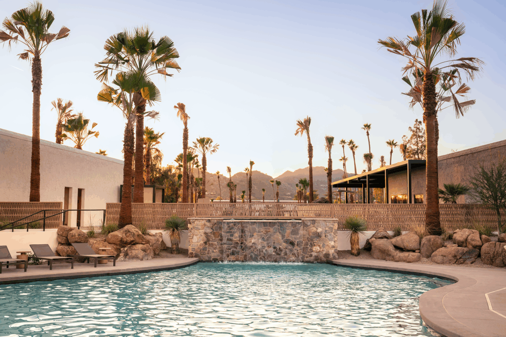 The pool at Kimpton Miralina Resort & Villas Paradise Valley surrounded by rocks and palm tree landscaping.