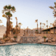 The pool at Kimpton Miralina Resort & Villas Paradise Valley surrounded by rocks and palm tree landscaping.
