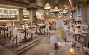 Clean, white tables and chairs at luxury dining at Luna by Giada at Caesars Republic Scottsdale.