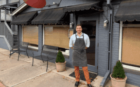 Chef Quincy Cherrett wearing an apron in front of Madeline restaurant in Denver.