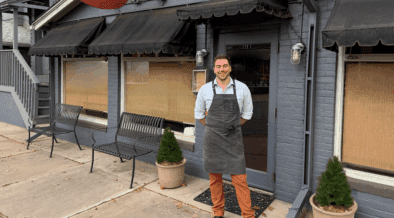 Chef Quincy Cherrett wearing an apron in front of Madeline restaurant in Denver.