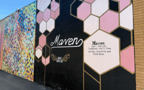 A mural wall of the Maven District in Salt Lake City resembling a beehive with an inspirational quote.