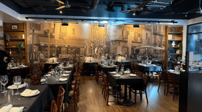 Pizzicata Glendale's dining area with old world Italy decor with matching wall mural and elevated table settings.