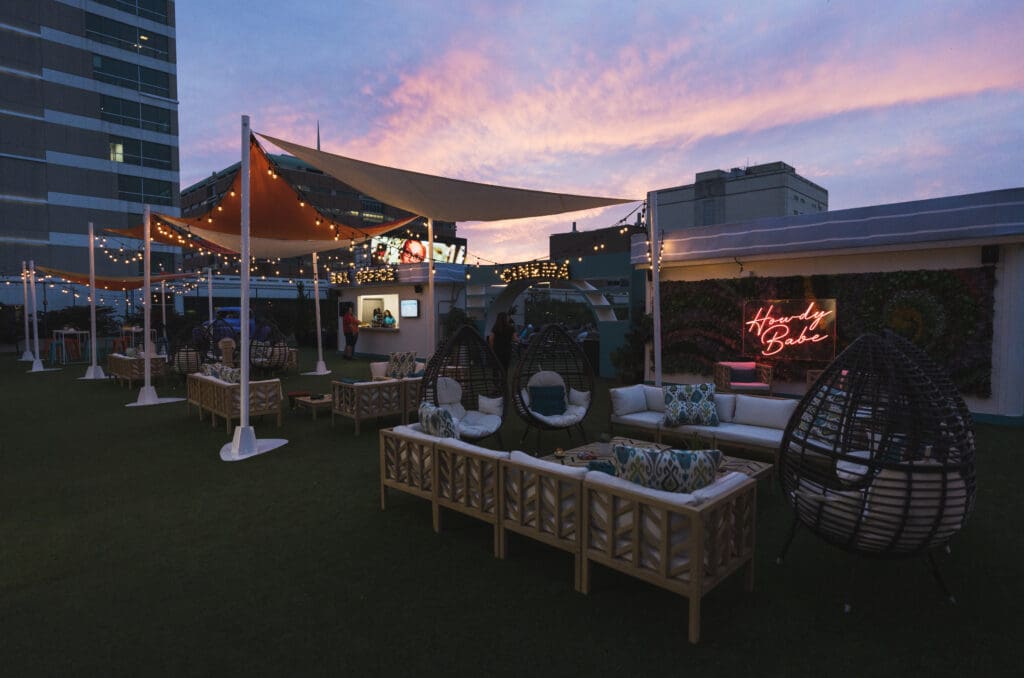 Rooftop Cinema Club Fort Worth at sunset featuring cozy lounge seating, string lights, outdoor bar, and romantic evening atmosphere for Valentine’s Day screenings.